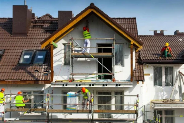 Equipe realizando pintura externa em residência